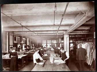 Men and women working on clothing designs in the art department at McCall